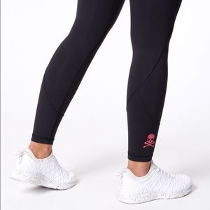 Lululemon Soulcycle In Movement 7/8 black tights, pink skull detail - size 6